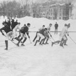 old black and white photograph of choldren playing hockey in old uniforms